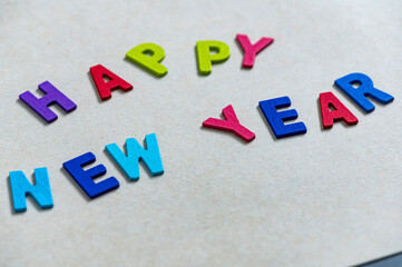 Happy new year font art colorful texting for greeting or celebrate card with light brown background, Sensitive Focus