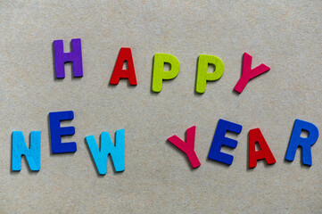 Happy new year font art colorful texting for greeting or celebrate card with light brown background, Sensitive Focus