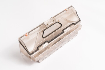 plastic container from the robot vacuum cleaner with garbage on a white surface.