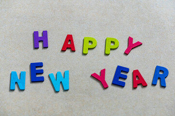 Happy new year font art colorful texting for greeting or celebrate card with light brown background, Sensitive Focus