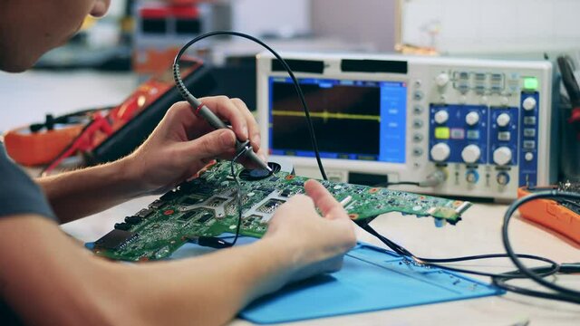 Male engineer is soldering elements of a circuit
