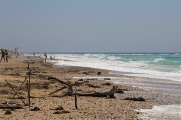 evocative image of a sandy beach with a sea of many colors and clear skies
