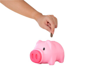 Hand putting coin into pink piggy bank isolated on white background. Selective focus. Savings for education, travelling, retirement, hospitalization concept.