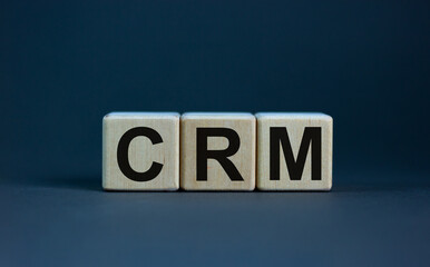 CRM symbol. Concept word 'CRM - customer relationship management' on cubes on a beautiful grey background. Business and CRM - customer relationship management concept.