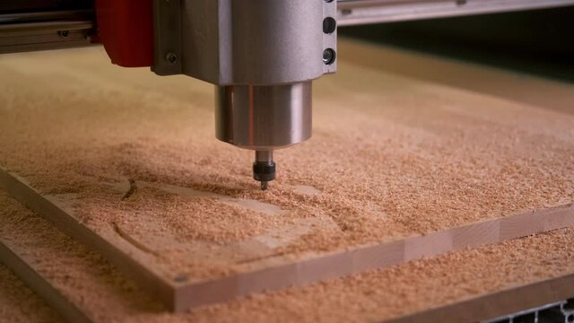 the CNC machine cuts a cutting Board out of wood along an automated route. Carving. Head close up