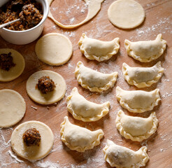 Traditional dumplings stuffed with groats and mushrooms top view. Delicious vegetarian dish