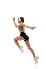 Dynamic. Caucasian professional female athlete, runner training isolated on white studio background. Muscular, sportive woman. Concept of action, motion, youth, healthy lifestyle. Copyspace for ad.