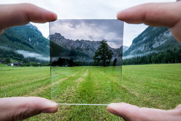 Professional photographer holding ND Gradient Filter glass appreciating an effect. Logar valley,...