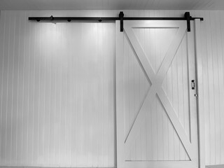 Large white sliding doors and black sliding rails against white walls.