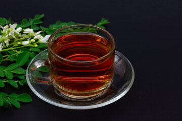 moringa tea  in transparent glass cup with fresh green moringa leaf and flower isolated on black background