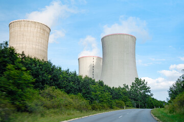 Three chimneys of nuclear power plant near the road. 