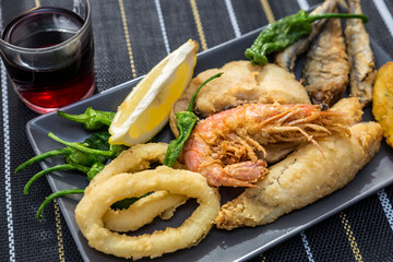 close up of dishes with golden fried fish and wine