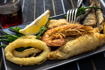 close up of dishes with golden fried fish and wine