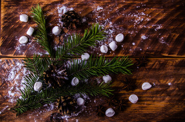 Obraz na płótnie Canvas Christmas cones and branches on wooden marshmallow boards