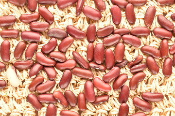 Fototapeta na wymiar Uncooked red beans, on a straw mat, close-up