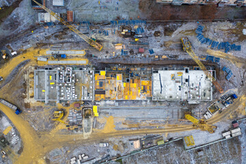 A construction site with yellow tower construction cranes - aerial top view - concept of housing...