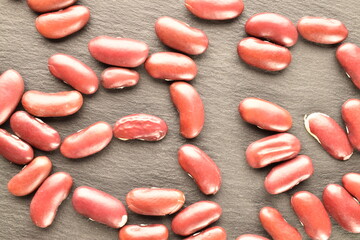 Raw red beans on a slate board, close-up.