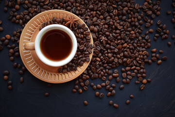 Fresh aromatic coffee in a Cup on a black background.