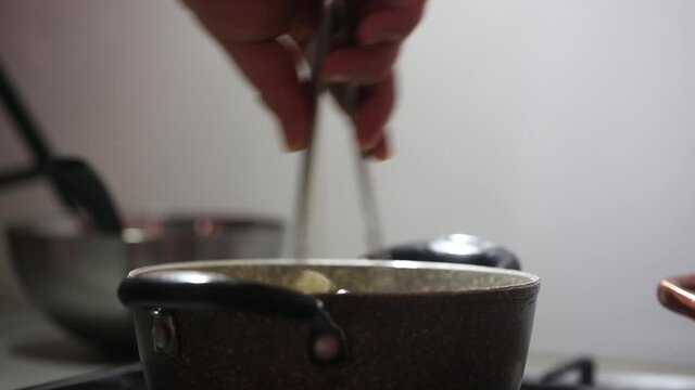 Chef prepares Asian noodles in a pot