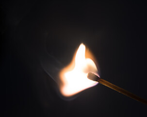 Fire burning on matchstick. Isolated on black background.