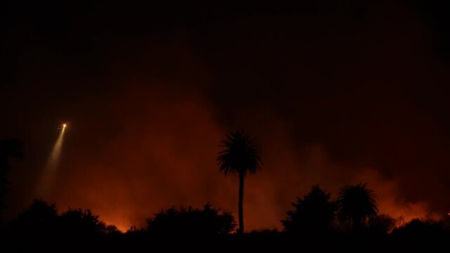 People watch massive fire burning at river bottom in Ventura, CA. 