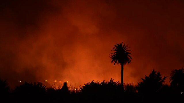 People watch massive fire burning at river bottom in Ventura, CA.