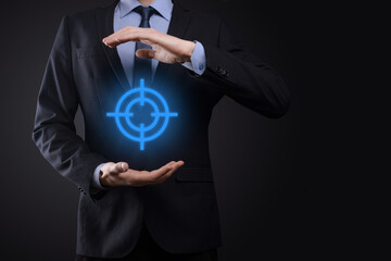 Targeting concept with businessman hand holding target icon dartboard sketch on chalkboard. Objective target and investment goal concept.