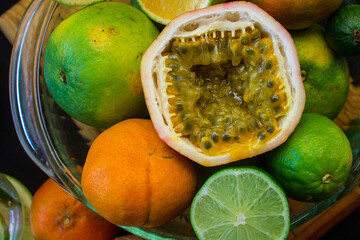 Parchita cut in half surrounded by a background of citrus fruits