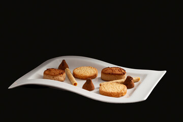Assortment of Spanish Christmas sweets made up of polvorones, chocolate bonbons, butter cookies and wafer eclairs.