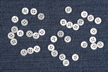 Plastic shiny buttons for clothes on a fabric background. Fashion and clothing. Factory industry