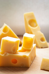 Pieces of fresh yellow cheese, chunk on wooden table. Dairy product concept