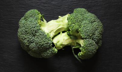 Photography of two bunches head to tail of broccoli on slate background for food illustrations