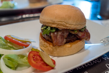 Juicy beef burger with bacon, vegetables and gluten free bun. Selective focus. Street food concept.