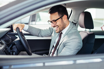 Businessman texting on his mobile phone while driving.