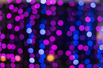 Christmas and New Year festive glitter bokeh background with purple, pink and blue colors.