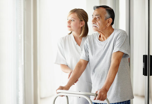 Nurse assisting patient with a walker