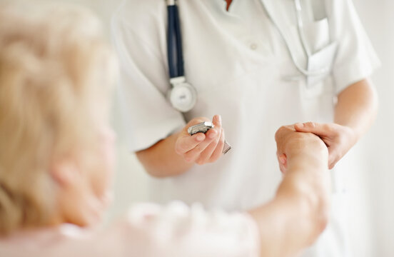 Nurse taking pulse of senior woman