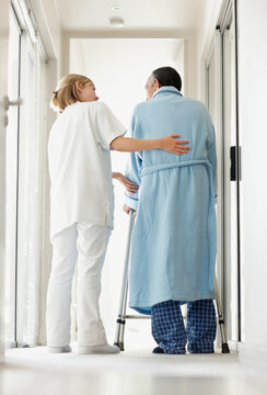 Nurse assisting patient with a walker