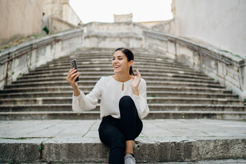 Young woman saying greetings on a video chat call meeting.Using a video meeting platform to stay connected.Smartphone app technology for internet communication.Virtual date.Online camera conversation