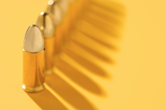 Row of gold bullets on yellow background