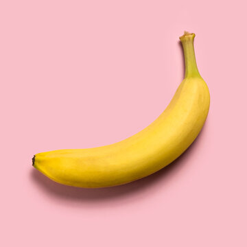 Ripe banana on pink background