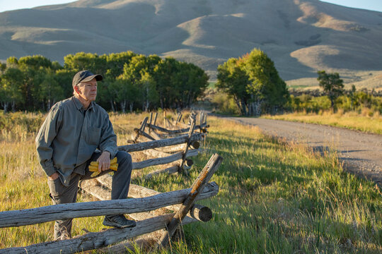 USA, Idaho, Bellevue, Farmer leaning against fence on field