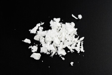 a pile of poured white artificial synthetic snow on a black background