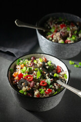 Two bowls with quinoa, paprika, beans and olives