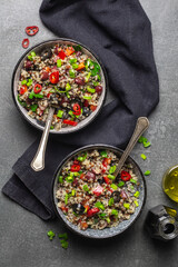 Two bowls with quinoa, paprika, beans and olives