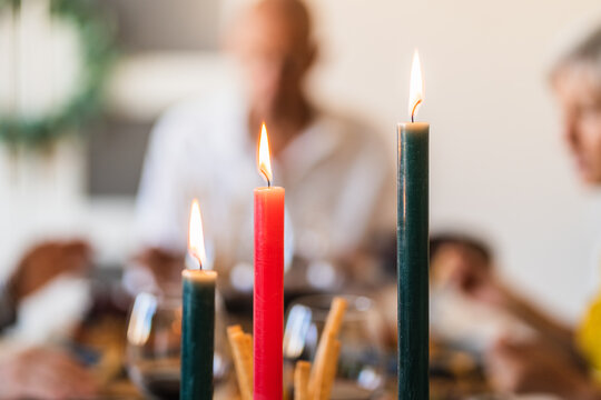 Bright wax candles with shiny flame on table during festive event on blurred background with bokeh effect