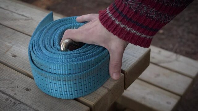 Male hand grabbing a slackline rope.