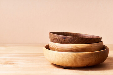 Empty wooden bowls of various shapes on bright studio background