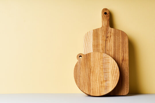 Wooden cutting boards of various shapes on bright studio background
