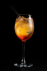 Alcohol cocktail Fiero spritz. Low alcohol cocktail of martini, gin tonic, orange and ice in a transparent glass on a black background.